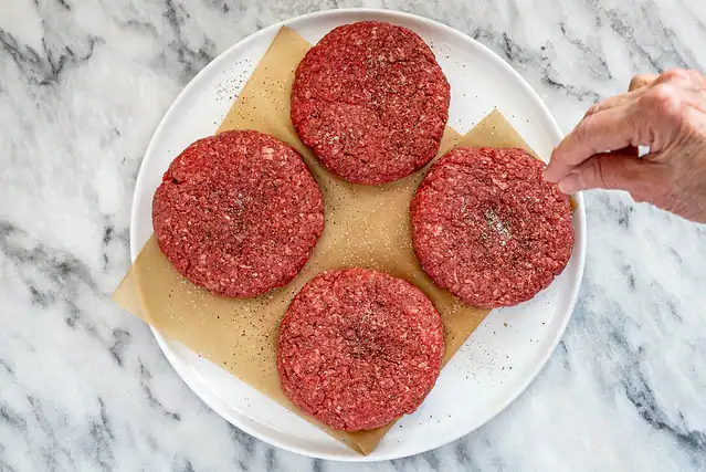 Shaping and seasoning burgers.