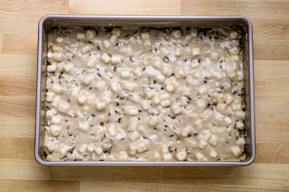 The brown sugar meringue mixture is spread over the mini marshmallows.