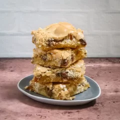 Rich, gooey chocolate chip blondie bars stacked on a small plate.