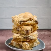 Stacked chocolate chip cookie bars on a small plate.
