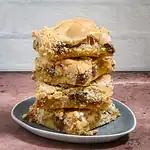 Butterscotch cookie bars stacked on a small plate with a rustic background.