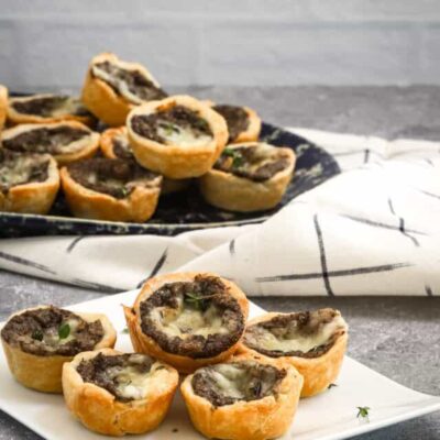 Mushroom tartlets being served with a scattering of thyme.