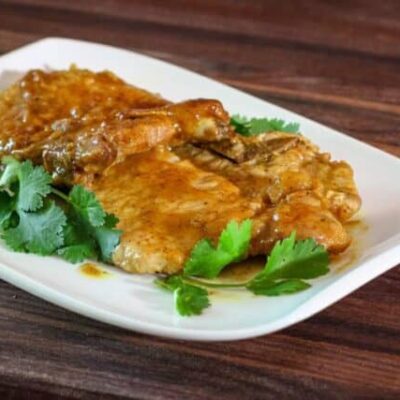 mustard glazed pork chops on a plate with cilantro