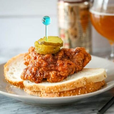 Nashville hot chicken on bread with pickles and beer