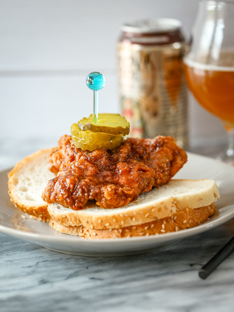 Nashville hot chicken on bread with pickles and beer