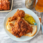 plate of nashville hot chicken with pickles and bread