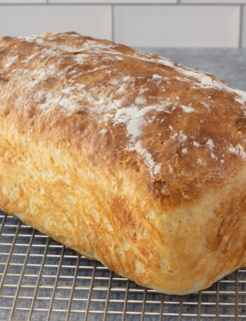 A loaf of no-knead bread on a cooling rack.