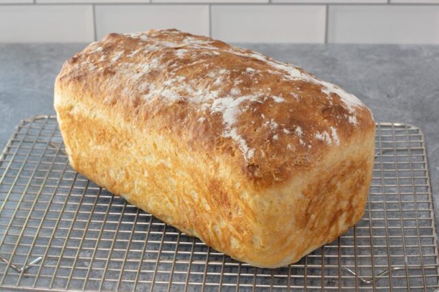 A loaf of no-knead bread on a cooling rack.