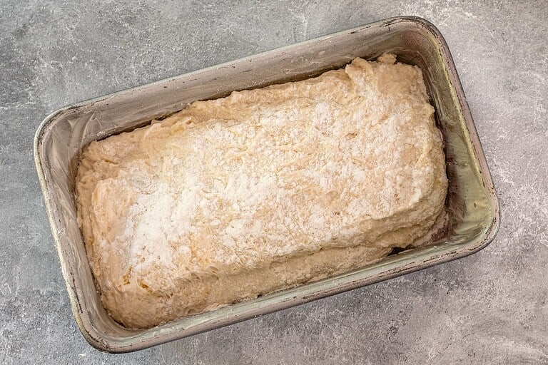 Bread dough in a metal loaf pan.