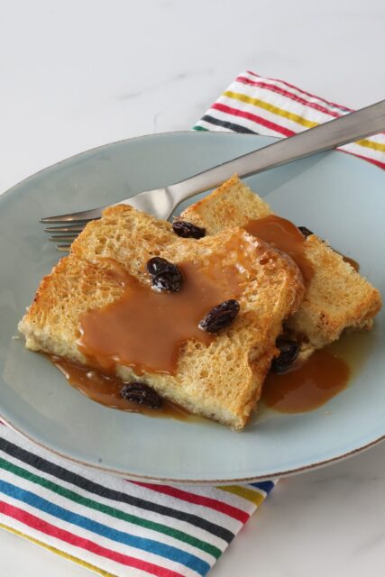 old-fashioned bread pudding on a plate with caramel sauce