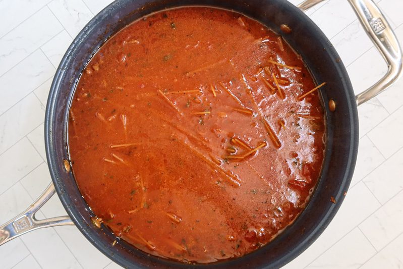 Add the broth and tomato sauce, then add the spaghetti.