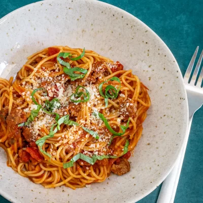 Savory spaghetti topped with fresh basil and grated cheese.