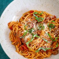 A serving of the one pot spaghetti dinner with basil and Parmesan cheese garnish.