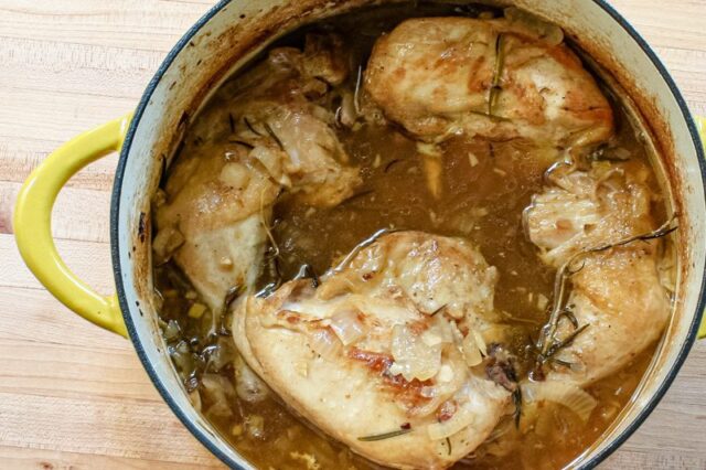 Oven braised chicken with rosemary, shown in the Dutch oven.