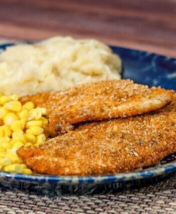 Panko crusted oven fried chicken on a plate with mashed potatoes and corn.