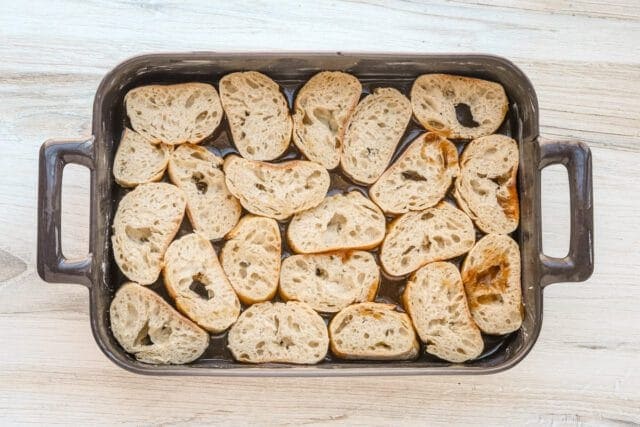 Baked bread pieces in a baking dish.