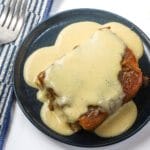 Golden fried chicken topped with creamy gravy.