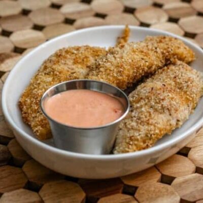 bacon and panko coated chicken tenders on a plate with dip