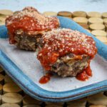 muffin shaped parmesan meatloaves on a serving plate
