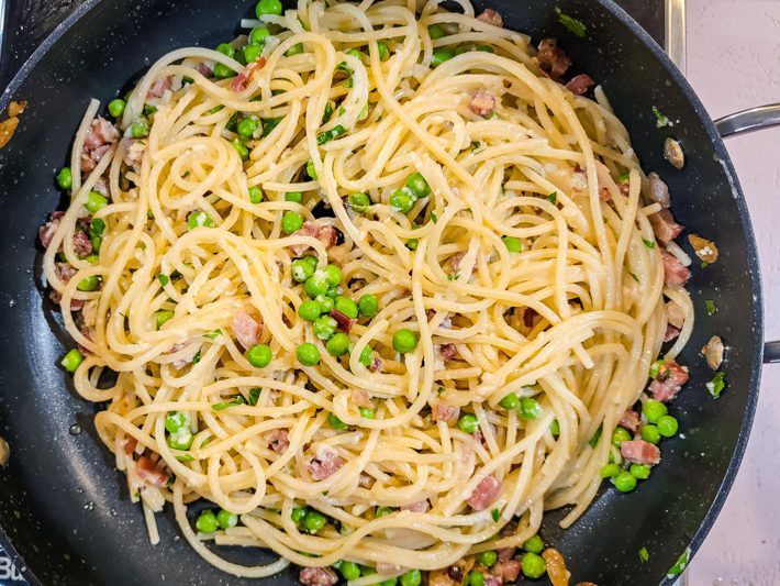preparing spaghetti with pancetta and peas
