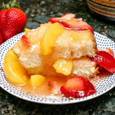 peaches and strawberry dessert sauce over angel food cake