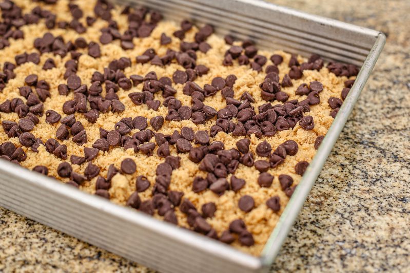 Peanut butter crumb cake prep: Chocolate chips are added to the crumb topping.