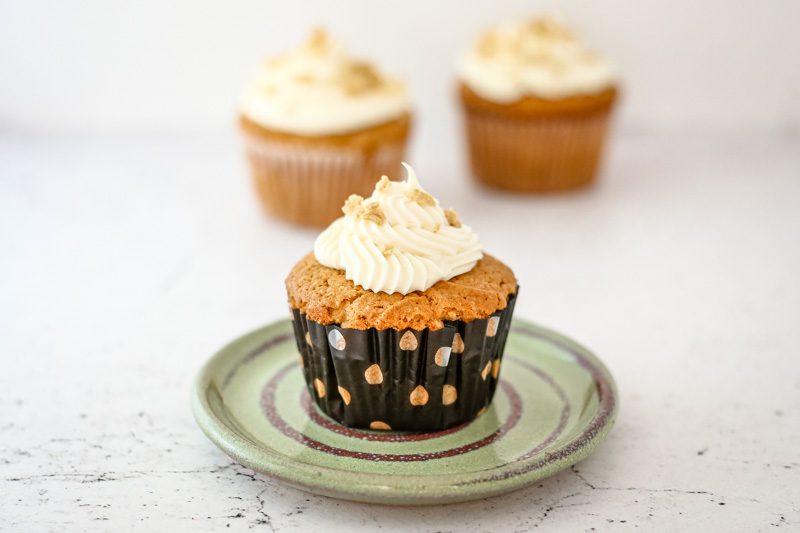 a peanut butter cupcake on a small plate, frosted