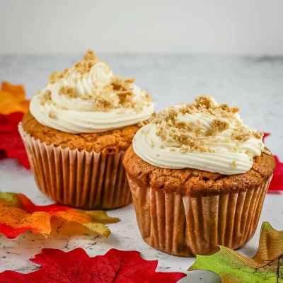 Freshly baked pumpkin cupcakes with creamy frosting and crumbled topping.