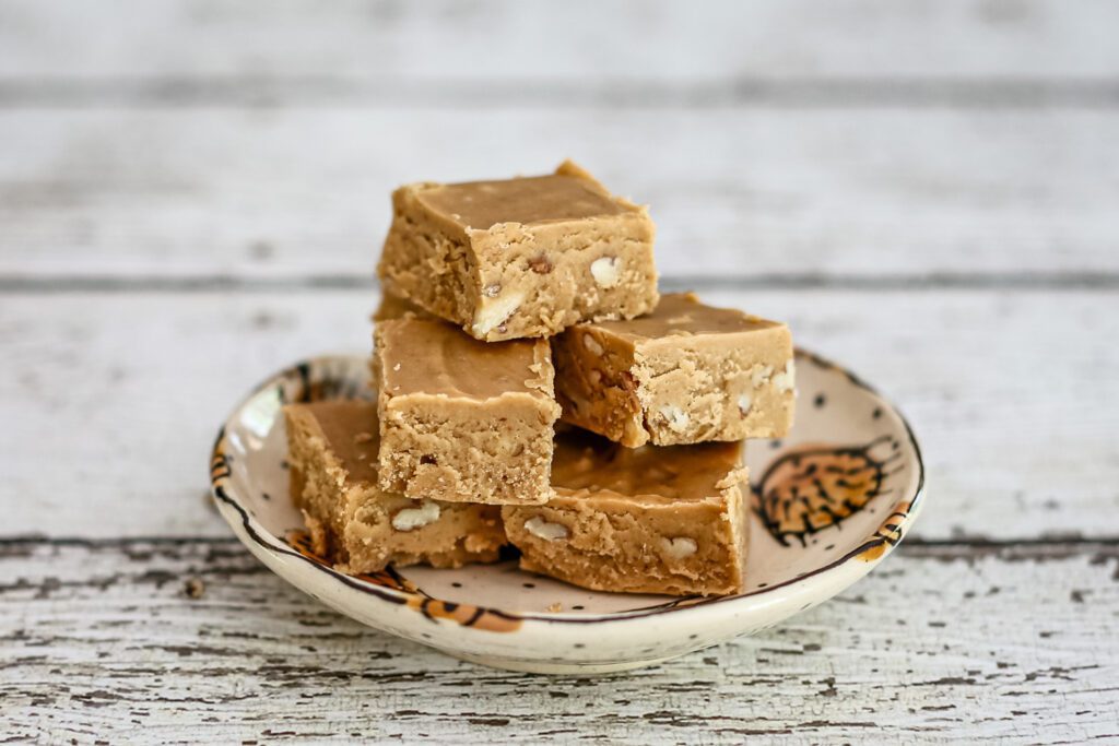 A small pottery plate with a stack of peanut butter fudge.