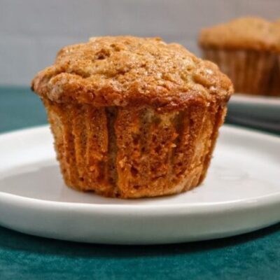 A pear muffin on a plate with more in the background