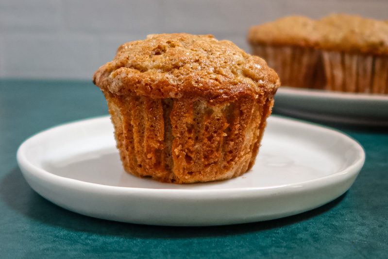 A pear muffin on a plate with more in the background