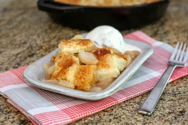 A dessert plate with a serving of pear pandowdy and ice cream