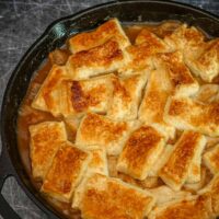 Pear pandowdy in a skillet with patches of pastry baked on top.