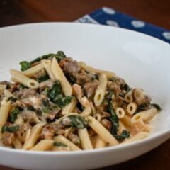 Creamy penne with sausage and spinach in a bowl