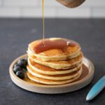 a stack of fluffy pancakes on a plate with maple syrup