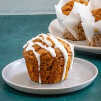 Pumpkin muffin on a plate with a simple vanilla glaze.