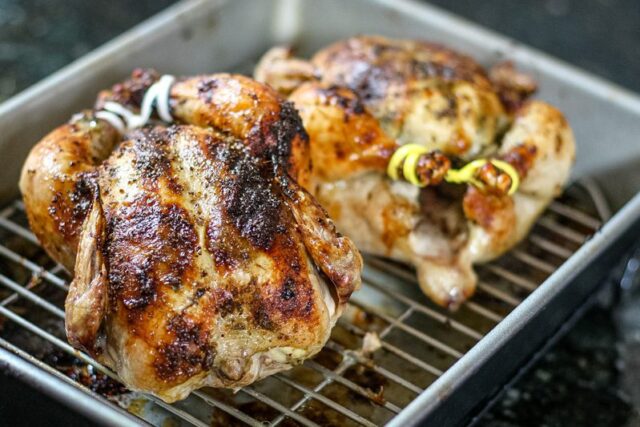 pesto coated Cornish game hens in a roasting pan