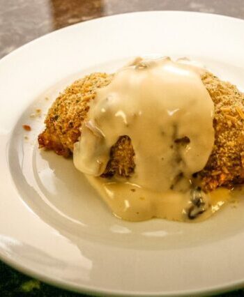 pesto chicken rolls on a plate with mornay sauce