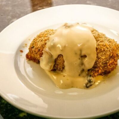 pesto chicken rolls on a plate with mornay sauce