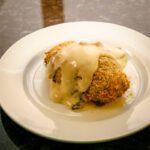 pesto stuffed chicken breasts with mornay sauce on a plate