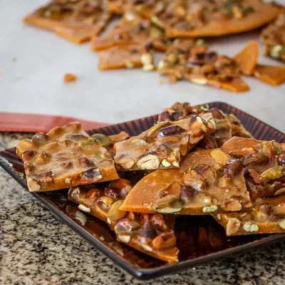 Layers of melted caramel and nuts on a flat surface.