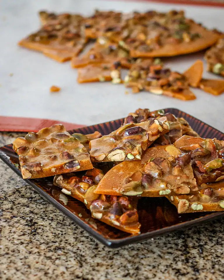 Layers of melted caramel and nuts on a flat surface.