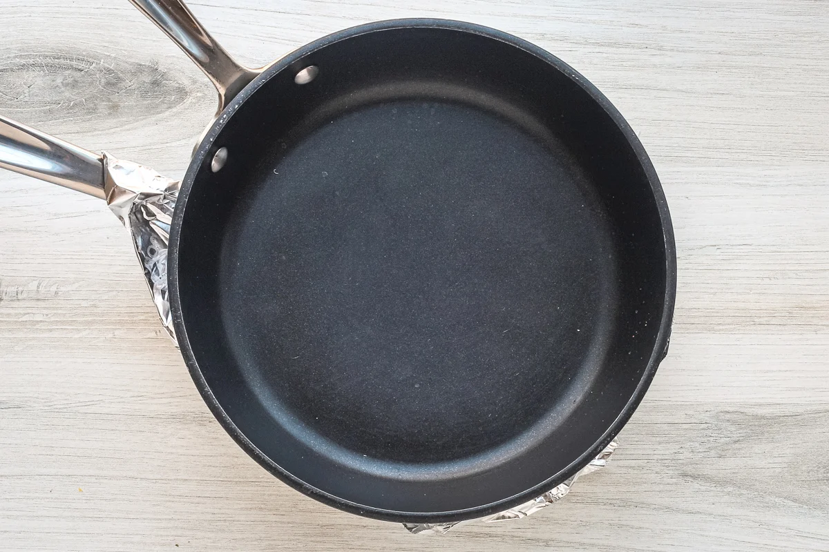 Buttered foil and a heavy pan will weigh the pommes Anna potatoes down as they bake.