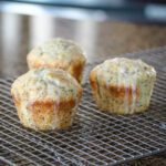 glazed poppy seed muffins on a cooling rack