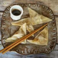 pork dumplings on a plate with dipping sauce