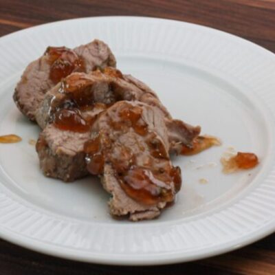 roasted pork tenderloin with jalapeño pepper glaze on a plate, sliced