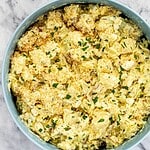 Creamy cauliflower casserole topped with breadcrumbs and fresh herbs.