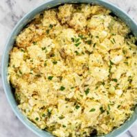 Creamy cauliflower casserole topped with breadcrumbs and fresh herbs.