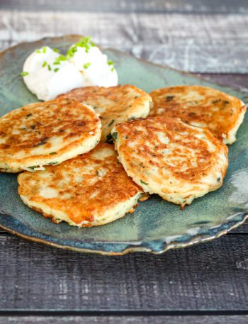 potato pancakes on a plate with sour cream