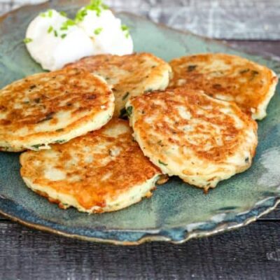 potato pancakes on a plate with sour cream